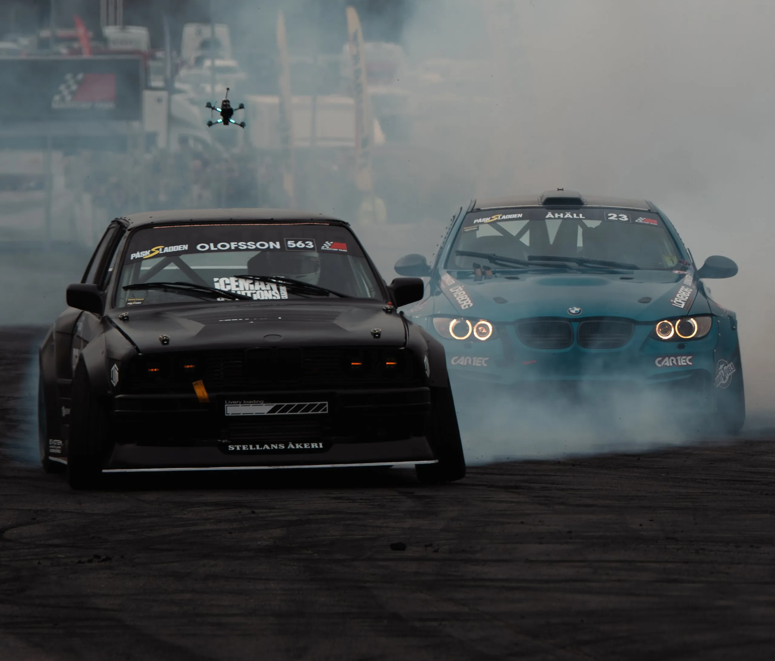 Svart BMW E36 och blå BMW driftar mot kameran