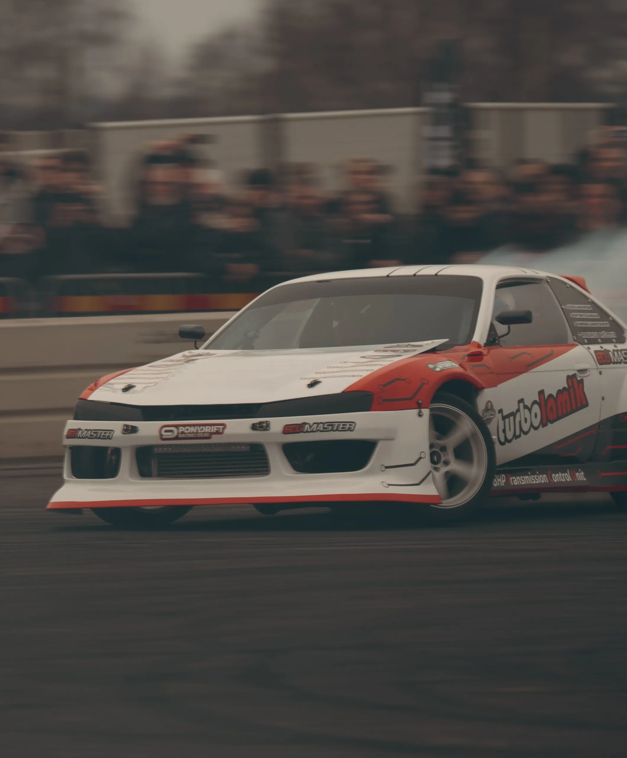 Vit och röd driftbil i full sladd