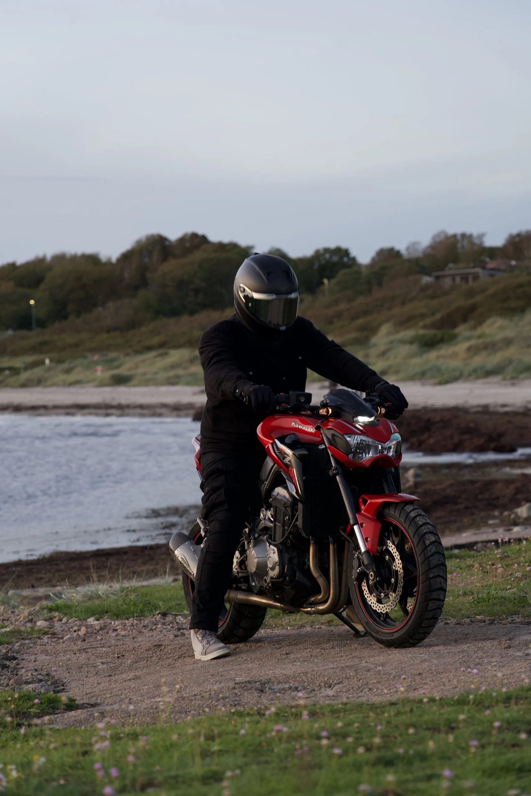 Förare på en röd Kawasaki Z900 vid stranden